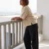 Mujer vistiendo blusa manga amplia de lino color paja y pantalon negro