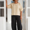 Mujer vistiendo blusa manga amplia de lino color paja y pantalon negro