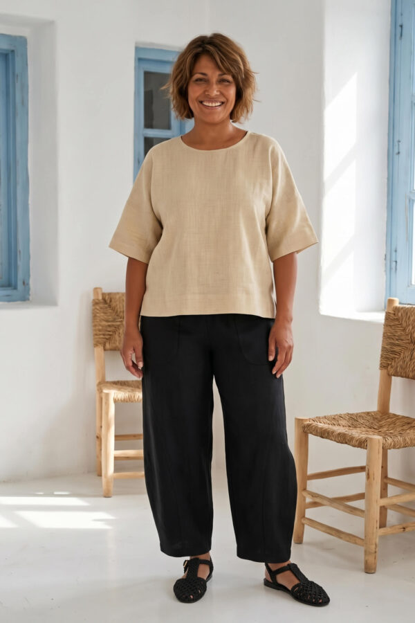 Mujer vistiendo blusa manga amplia de lino color paja y pantalon negro