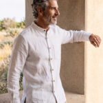 Hombre vistiendo camisa blanca de manga larga y cuello Mao en lino natural