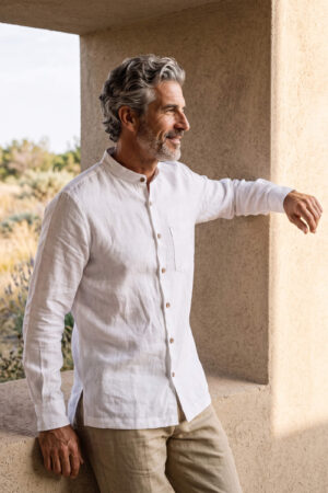 Hombre vistiendo camisa blanca de manga larga y cuello Mao en lino natural
