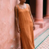 Mujer vistiendo vestido largo de lino bambú color naranja caramelo