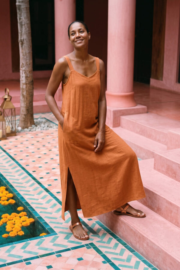 Mujer vistiendo vestido largo de lino bambú color naranja caramelo