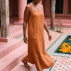 Mujer vistiendo vestido largo de lino bambú color naranja caramelo