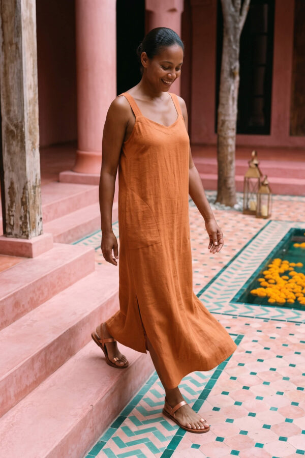 Mujer vistiendo vestido largo de lino bambú color naranja caramelo