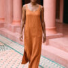 Mujer vistiendo vestido largo de lino bambú color naranja caramelo