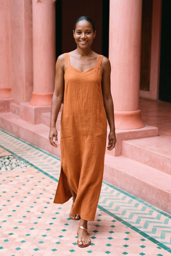 Mujer vistiendo vestido largo de lino bambú color naranja caramelo