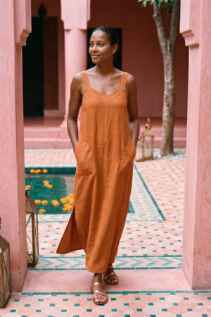 Mujer vistiendo vestido largo de lino bambú color naranja caramelo
