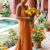 Mujer vistiendo vestido largo de lino bambú color naranja caramelo
