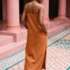 Mujer vistiendo vestido largo de lino bambú color naranja caramelo