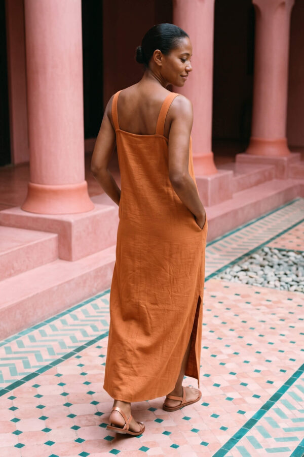 Mujer vistiendo vestido largo de lino bambú color naranja caramelo